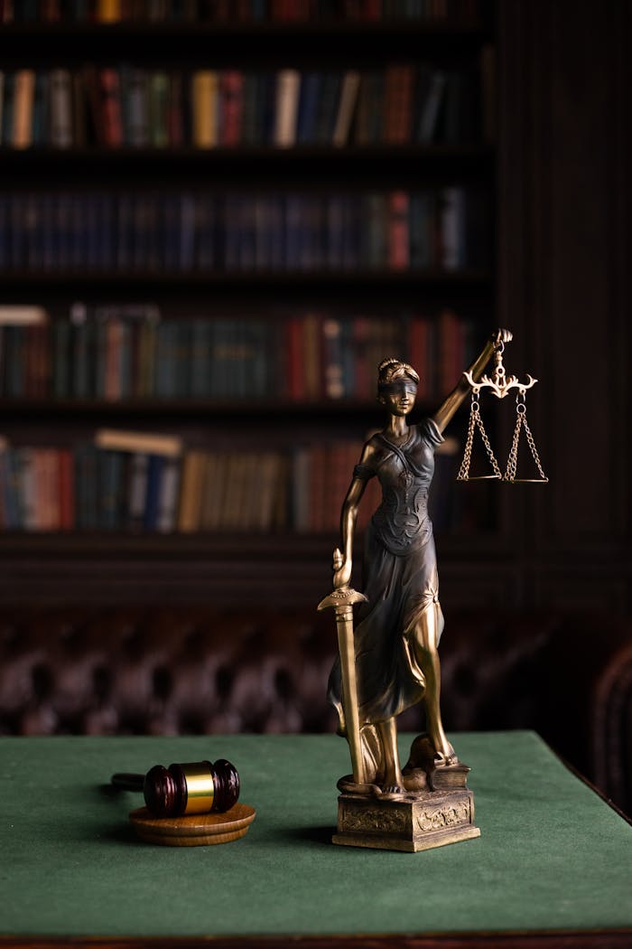 digital Lady Justice and gavel on a table in a classic law library setting.
